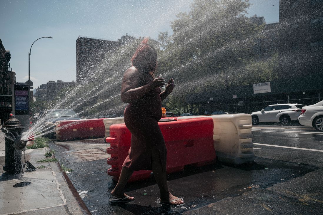 Tameka Jones steps through an opened fire hydrant on Broadway in West Harlem on Saturday, July 23rd.